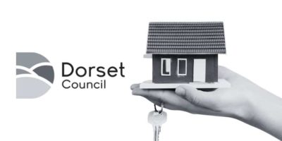 Image shows the Dorset Council Logo alongside a small miniature property held in a hand with a set of keys.