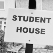 Black and white image of board outside residential house stating Student House